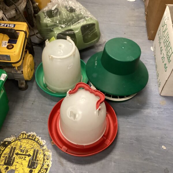 White plastic bird feeder for poultry, showing signs of use.
