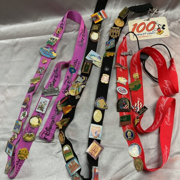 Collection of enamelled pin badge lanyards with Disney and national park pins.