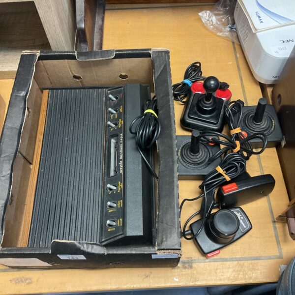Vintage Atari 2600 woody console with joysticks for retro gaming.