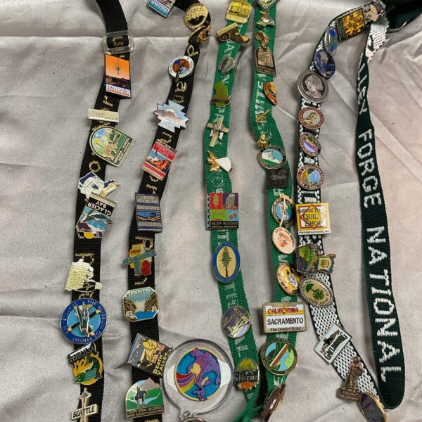 Full view of three enamel pin badge lanyards with travel souvenirs.