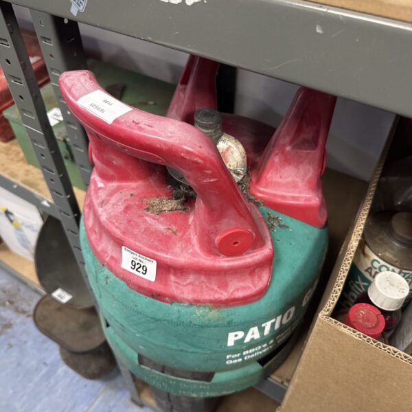 Red metal patio gas canister with visible wear and tear.
