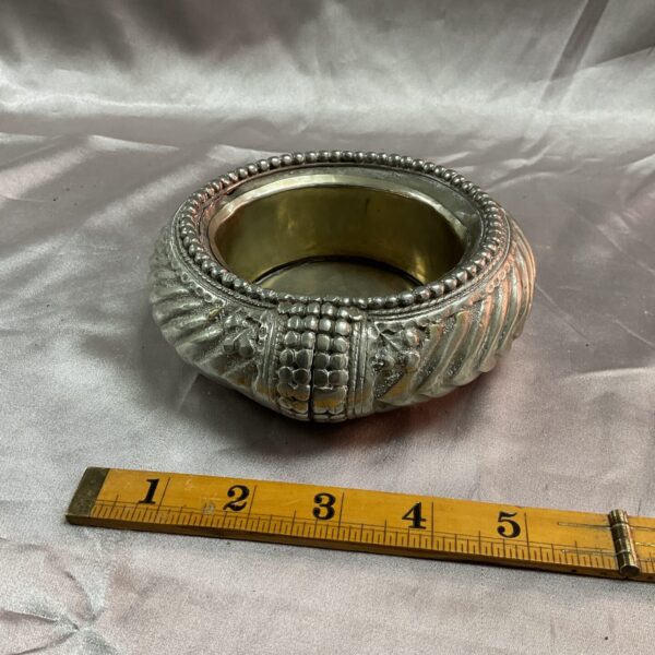 Intricate embossed detailing on a vintage Indian silver dish.
