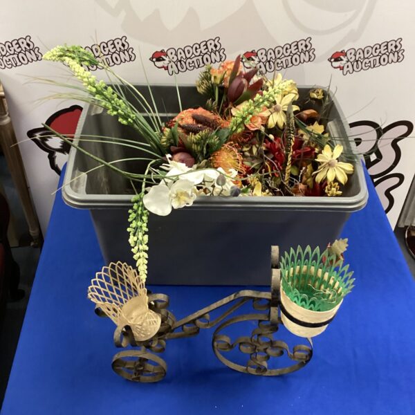 Colourful artificial flower arrangement with vases and bicycle pot.