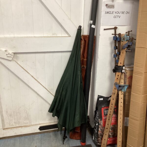 A collection of fishing rods and a dark green umbrella.