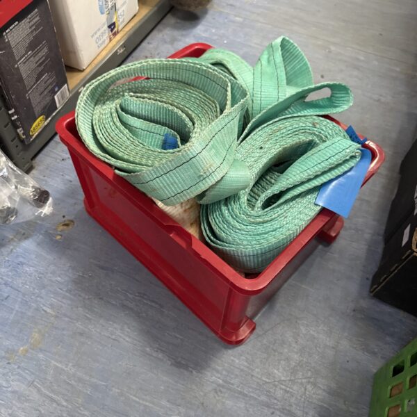 A box of used cargo straps for vehicle transport and securing.