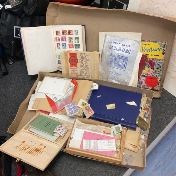 Vintage stamp collection with loose stamps and albums displayed.