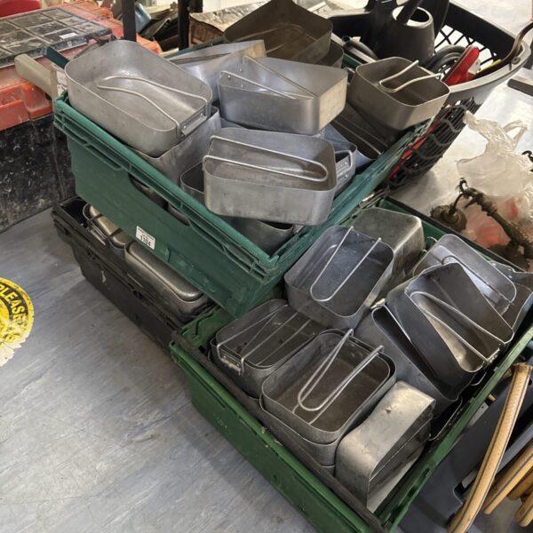 Stack of vintage mess tins, military surplus, in a tray.