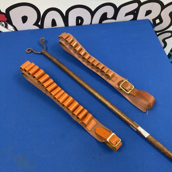 Vintage shooting stick and leather cartridge belts for hunting.