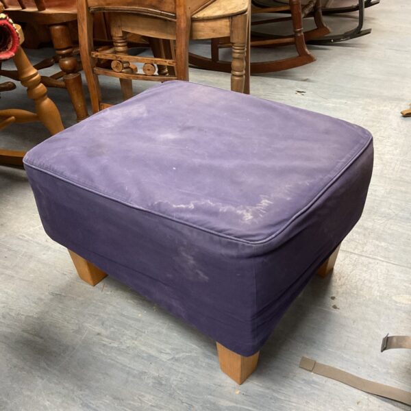 Vintage purple footstool with wooden legs, ideal for home decor.