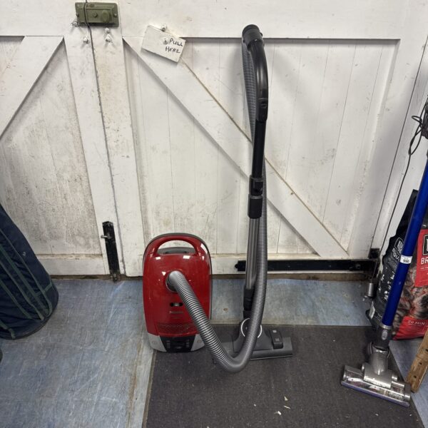 Red Miele Compact C2 cylinder vacuum cleaner with telescopic wand.