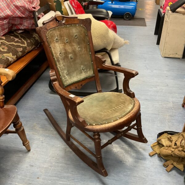 Antique walnut rocking chair with upholstered seat and curved back.