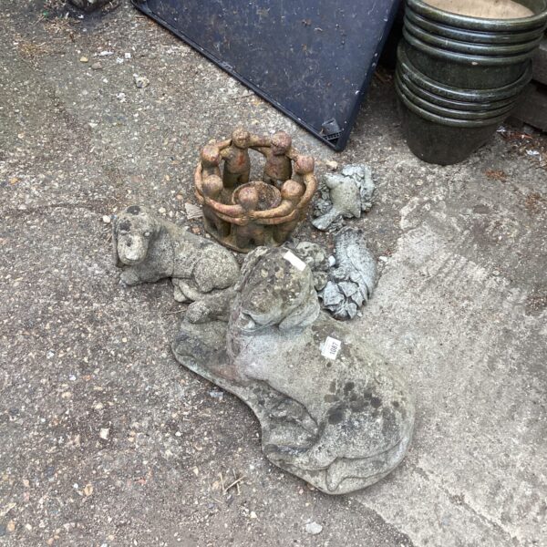 Weathered concrete garden dog ornament for outdoor display.