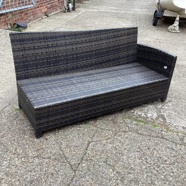Woven raffia effect garden bench in a garden setting.