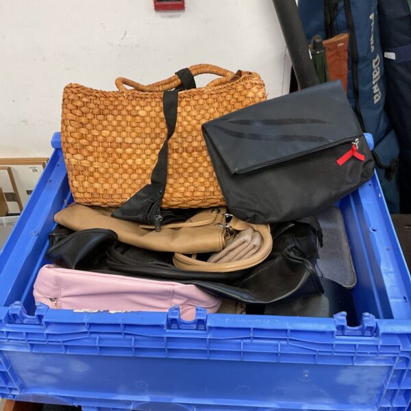 Large crate filled with assorted ladies handbags and bags.