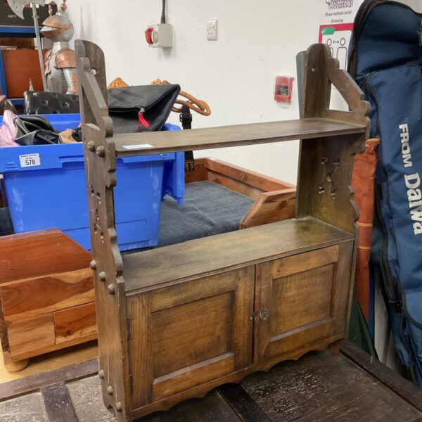 Vintage wooden wall shelf with small cupboard for storage.