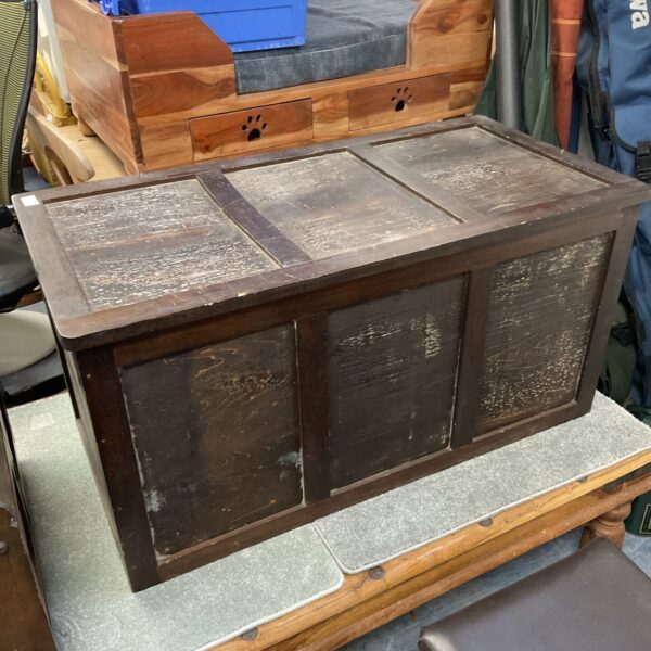 Front view of a vintage wooden blanket chest with rustic details.