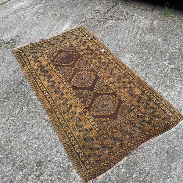 Vintage mid-century modern rug with orange and brown geometric pattern.