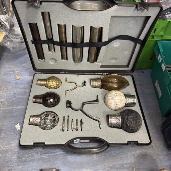 Vintage curtain pole display set with brass fittings in a case.