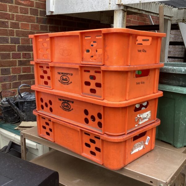 Three orange plastic storage crates stacked, ideal for industrial storage.