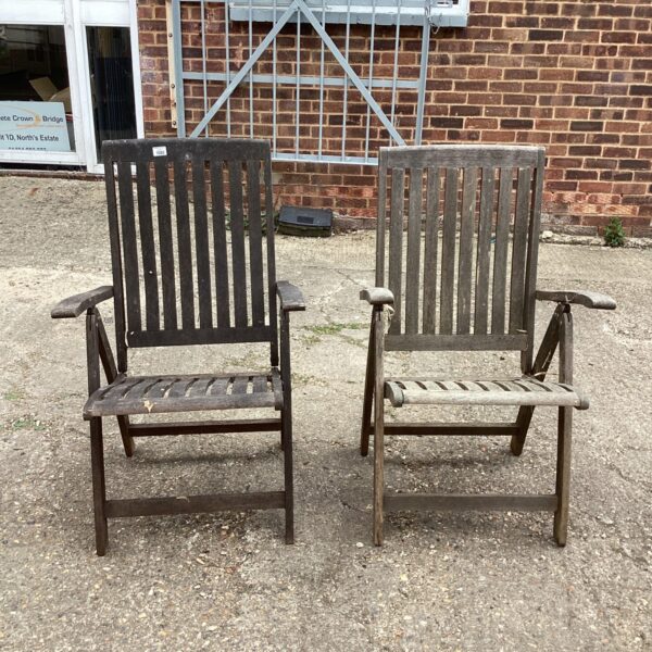 Pair of vintage hardwood garden chairs in a garden setting.