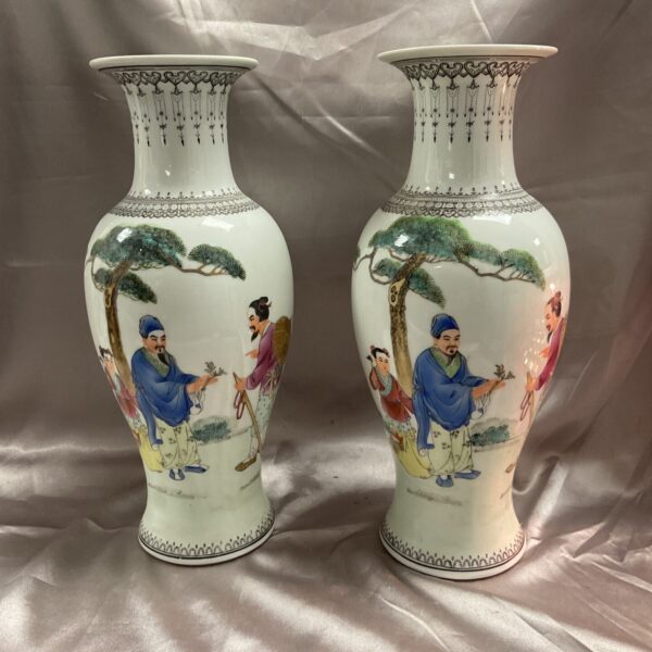 Pair of vintage Famile Rose porcelain vases with detailed scenes.