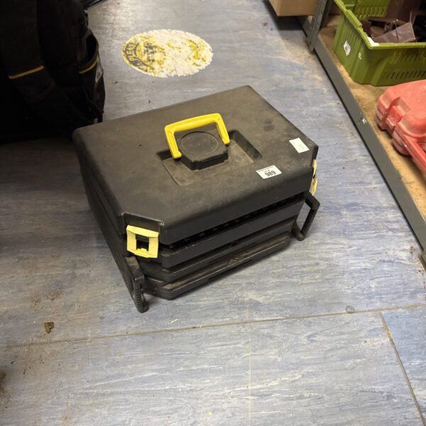 Black step toolbox with tiered compartments and tools inside.