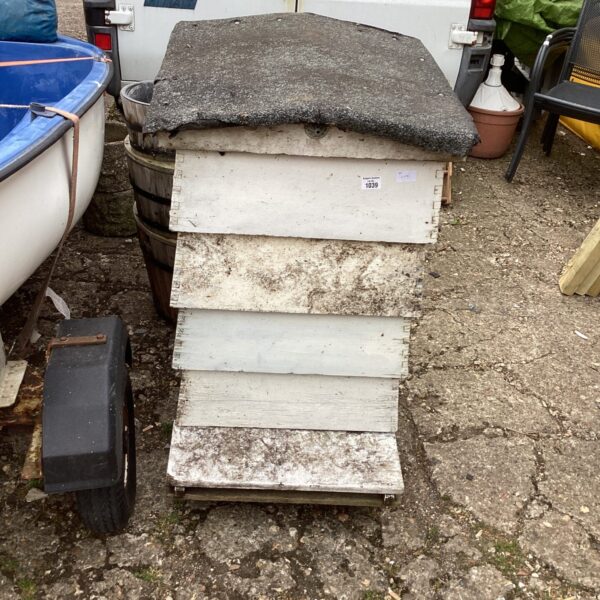 Vintage wooden bee hive in a garden setting.