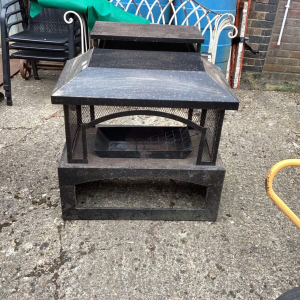 Weathered metal garden fire pit for outdoor heating.
