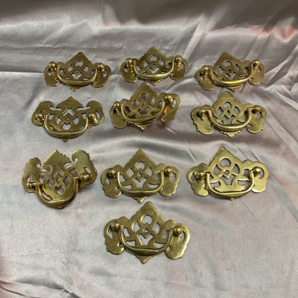 Lot of ten ornate brass drawer handles for furniture.