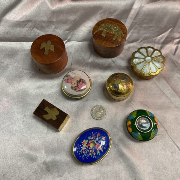 Collection of vintage pill pots and small storage containers.