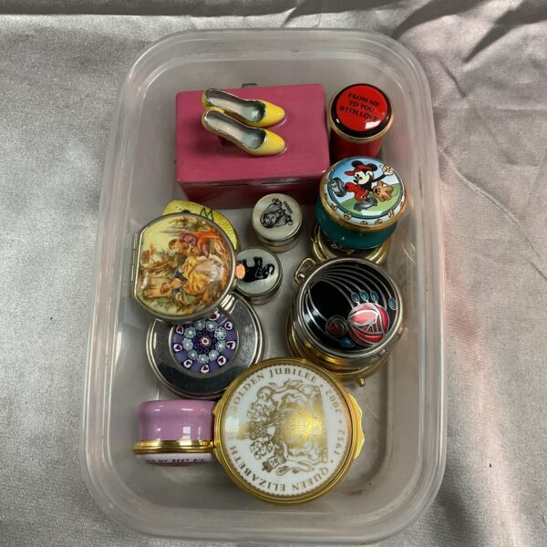 Tray of assorted vintage pill boxes, collectible miniature containers.