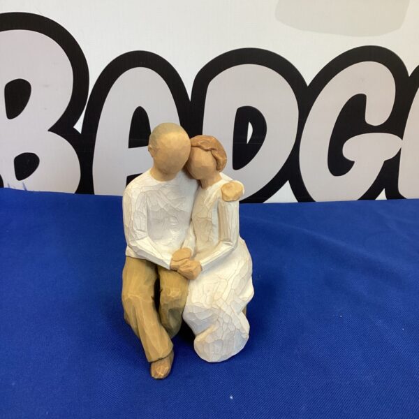 Close-up of a Willow Tree figurine depicting an embracing couple.