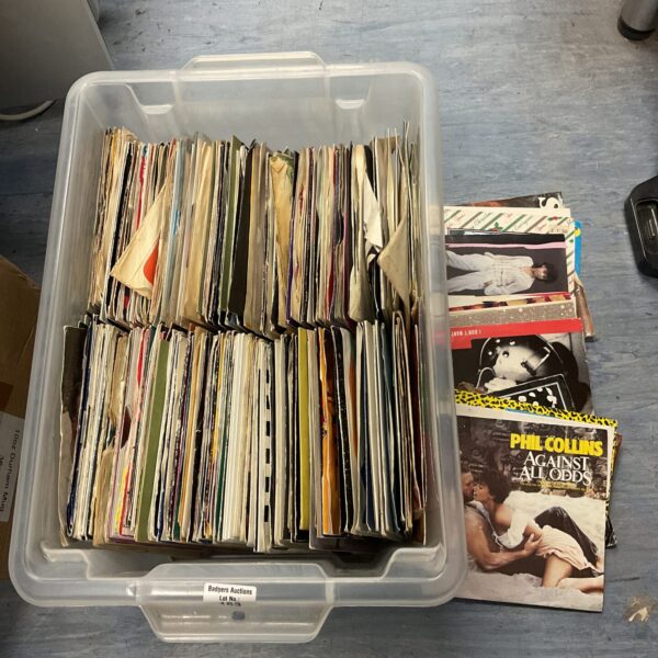 Large lot of 7 inch vinyl records in a plastic container.