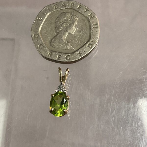 Close-up of a 9ct gold peridot and diamond pendant.