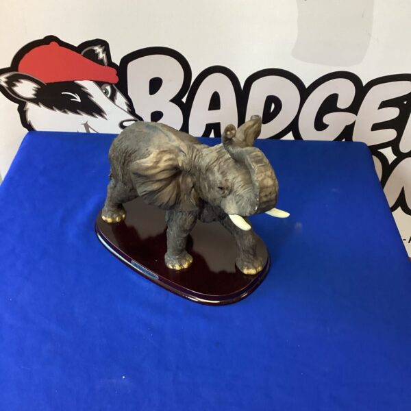 Detailed ceramic elephant figurine on a base, collectible animal ornament.