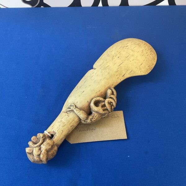 Detailed view of a resin Maori war club with woven handle.