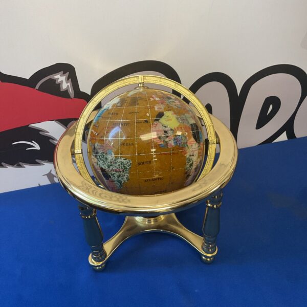Detailed gemstone globe on a brass stand, decorative world map.