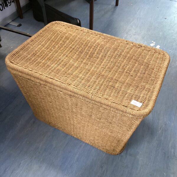 Wicker basket containing a clear glass vase for home decor.