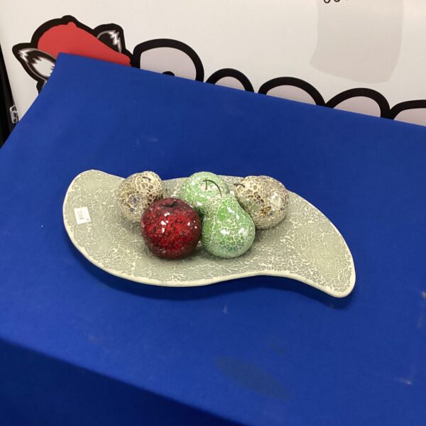 Vibrant mosaic glass fruit displayed on a white plate.