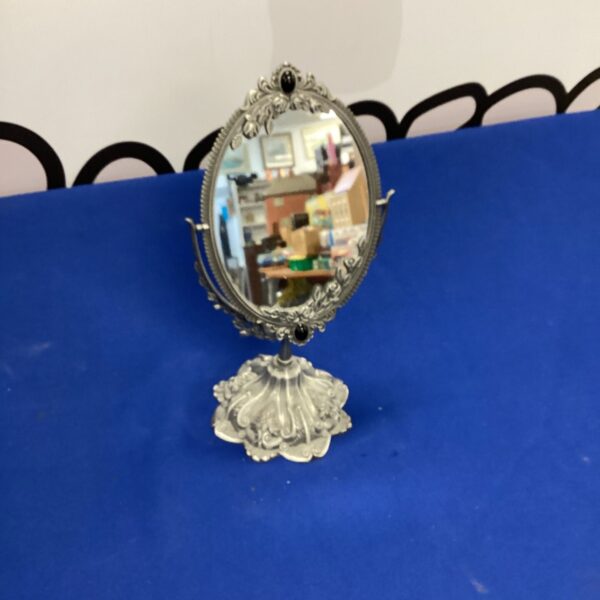 Ornate vintage vanity mirror with detailed metal frame.