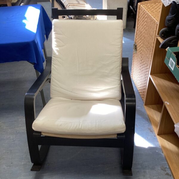Vintage rocking chair with light upholstery and wooden frame.