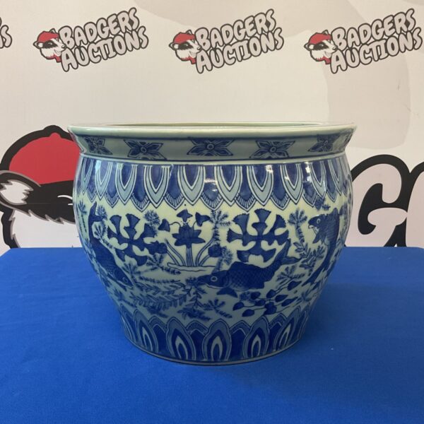 Detailed blue and white Chinese koi fish planter for garden decor.