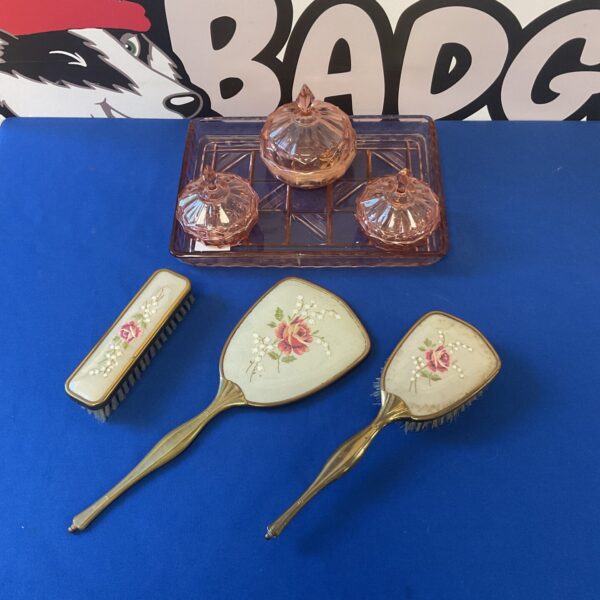 Vintage pink dressing table set with embroidered brass brushes and mirror.
