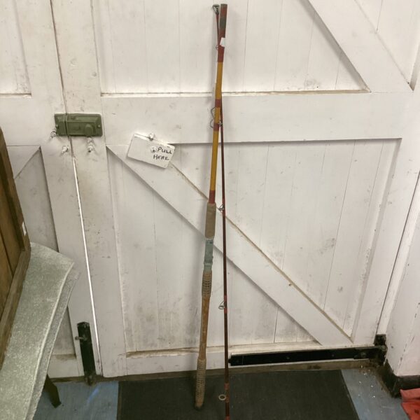 Vintage bamboo fishing pole with cork handle and guides.