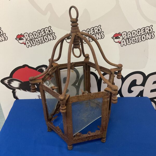 Antique wrought iron lantern with glass panels and intricate detailing.