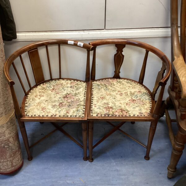 Antique Edwardian mahogany corner chairs with floral upholstery.