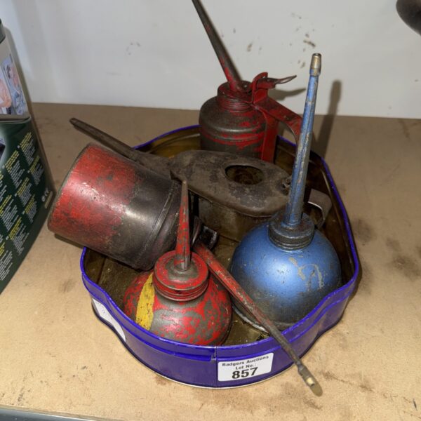 Selection of vintage metal oil dripper cans in red, blue, and silver.