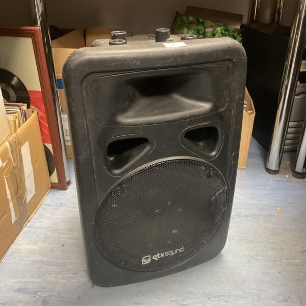 Black Qtx PA speaker with front grille, portable audio equipment.