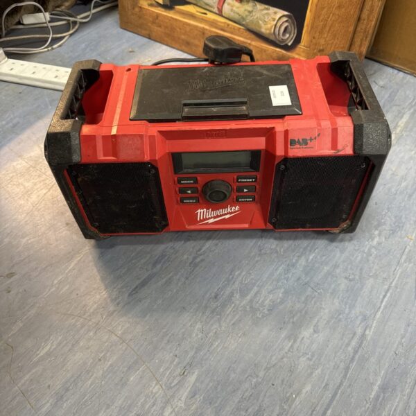Red Milwaukee M12 DAB+ site radio with damaged screen.