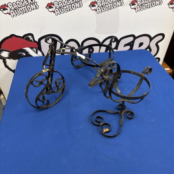 Vintage wrought iron duck and tricycle plant pot holders for garden display.